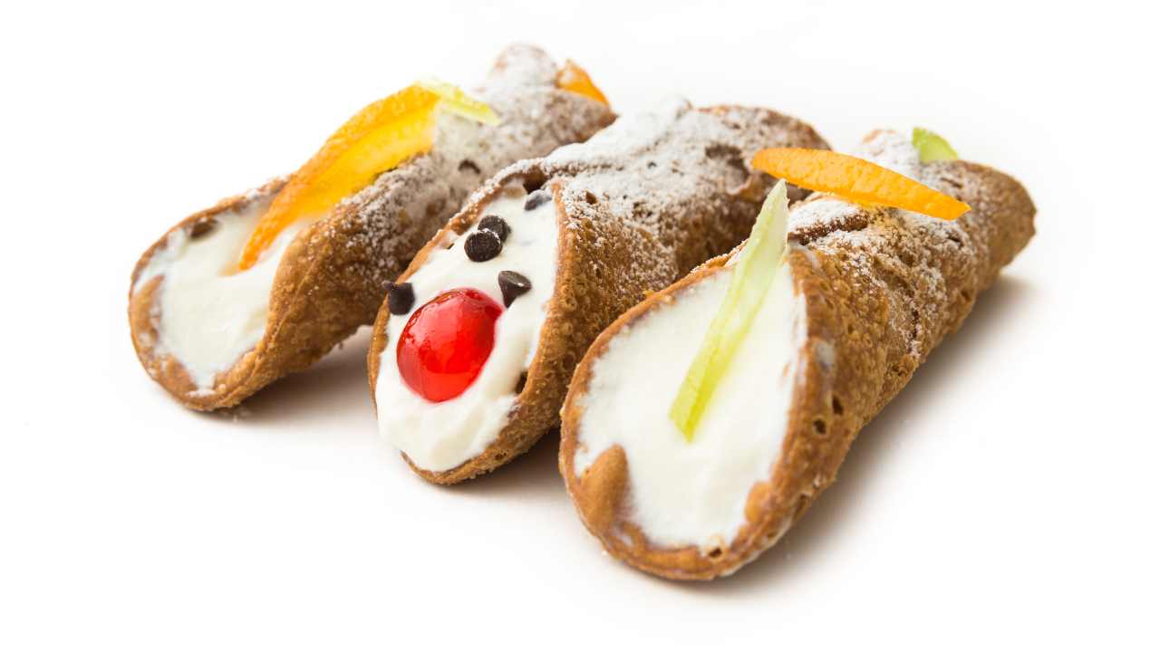 Tre cannoli con ricotta e altri ingredienti