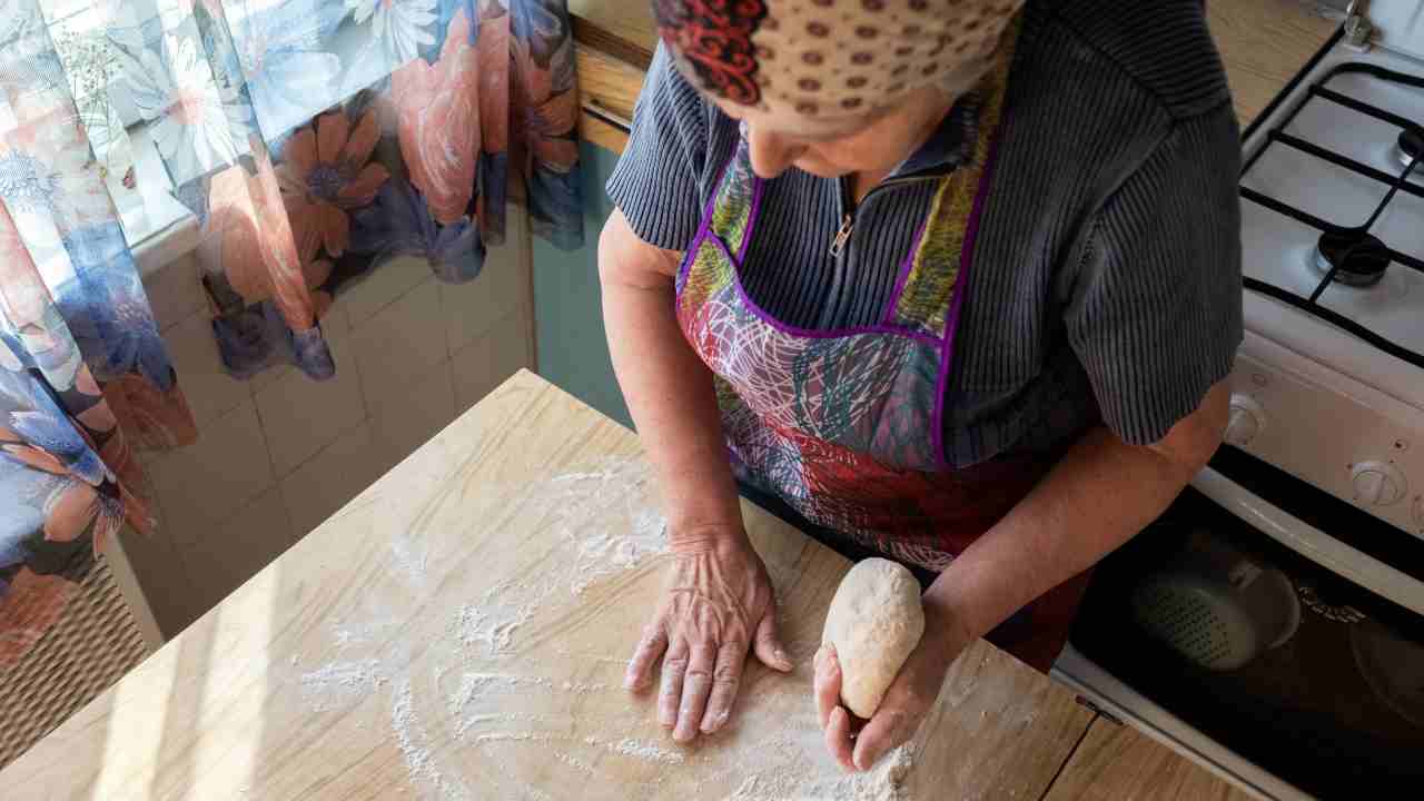 Una donna anziana mentre prepara un dolce
