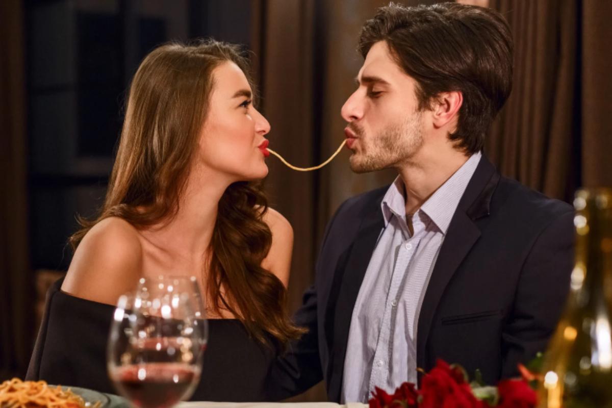 uomo e donna che mangiano spaghetti al ristorante