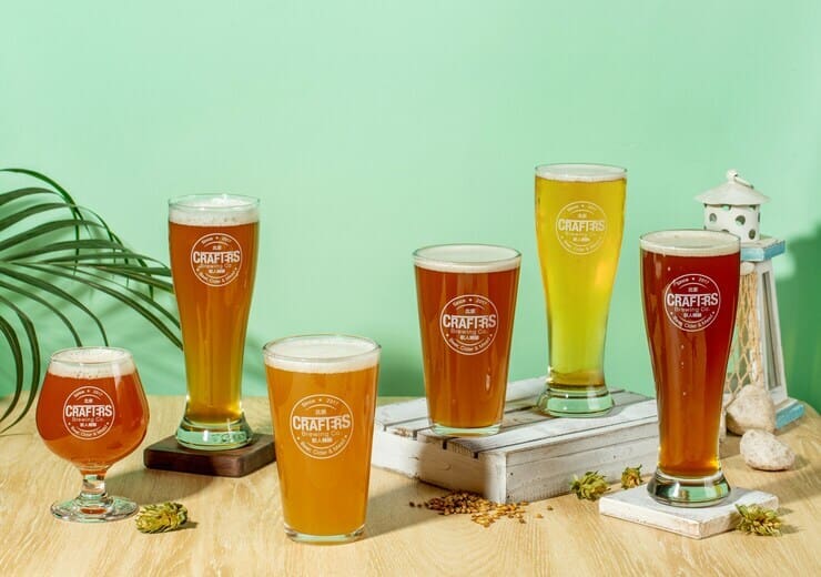 Bicchieri di birra di vario colore su sfondo verde