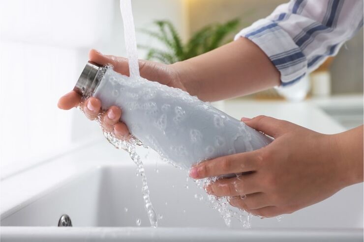 Lavare borraccia sotto acqua corrente