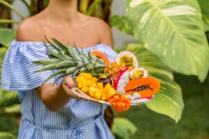 Donna con vassoio di frutta esotica